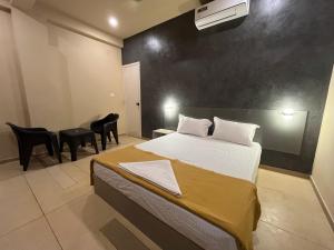 een slaapkamer met een bed en stoelen erin bij Rocks beach house in Kannur +17 foto's