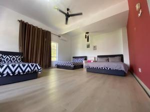 a large room with two beds and a couch at D Pine Villa in Bukit Tinggi