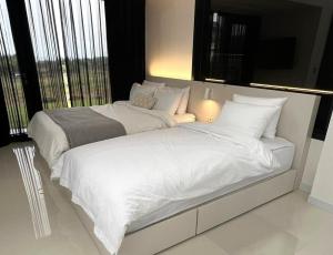 a large white bed in a room with a window at Daejung Secret Gennie Poolvilla in Seogwipo