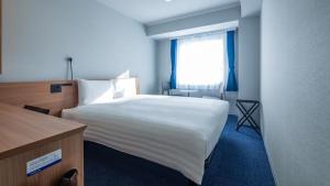 Postel nebo postele na pokoji v ubytování Toyoko Inn Osaka Yodoyabashi-eki Minami