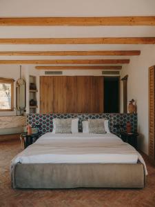 a large bed in a bedroom with wooden ceilings at The Wild by Interni in Kalafatis