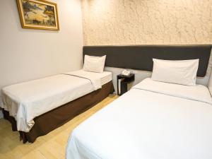 Voodi või voodid majutusasutuse Grande Hotel Lampung Powered by Archipelago toas
