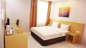 Voodi või voodid majutusasutuse Grande Hotel Lampung Powered by Archipelago toas