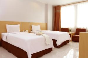 Voodi või voodid majutusasutuse Grande Hotel Lampung Powered by Archipelago toas