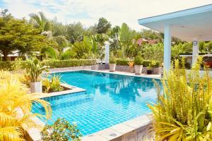 a swimming pool in a garden with plants at Destination39 in Thalang