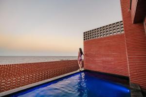 a woman standing next to a brick wall with a pool at Pohang Case Poolvilla in Pohang +29 photos