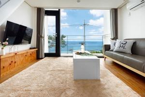 a living room with a couch and a large window at Yeongdeok Island 107 in Yŏngdŏk