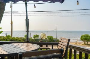 a table and bench with a view of the beach at Yeongheungdo Haesong Pension in Incheon