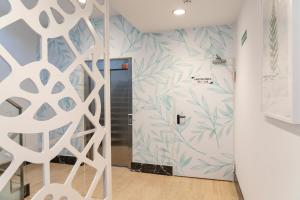 a hallway with a door with a mural of leaves at Ele Route 42 in Illescas +69 photos