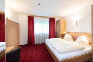 Postel nebo postele na pokoji v ubytování Hotel Gasthof Kröll - inkl Nationalpark-Karte, 1 x Grossglockner Hochalpenstraße kostenlos, verschiedene Bergbahnen kostenlos, Badesee kostenlos, Bus & Zug kostenlos, regionale Küche