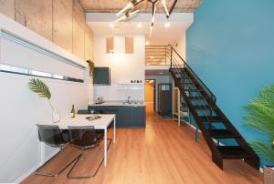 a kitchen and dining room with a spiral staircase at Daecheon Boryeong the Playa Pension in Boryeong