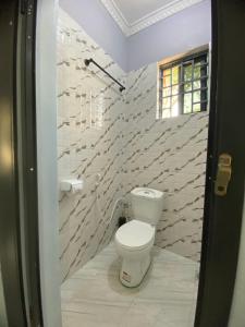 a bathroom with a toilet and a stone wall at COMFORT HAVEN Studio in Ilemera +10 photos