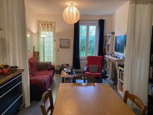 un soggiorno con tavolo e un soggiorno con divano. di La Chambre Claire a Ponts-et-Marais