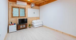 GongjuGongju Goma Guesthouse的客厅配有白色椅子和电视