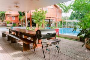 a grill sitting on a table next to a pool at Wooden Homestay LAGI in Hàm Tân +35 photos