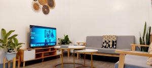 a living room with a couch and a tv at 4BR Entire Floor - 2 Adjacent Units, 2BR Each Unit, with Balconies and Mountain View in Baguio