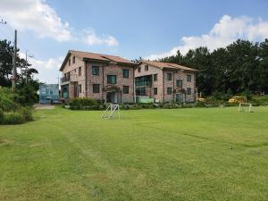 a large yard with two soccer balls in front of a building at Iksan haneulsup pension in Iksan