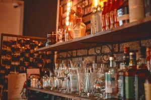 a bar with glasses on a shelf with bottles at Jeju Hadoya Beer N Bed in Jeju