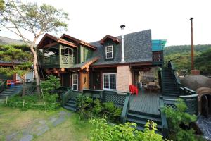 a large house with a porch and a deck at Boryeong Rich Valley Log Village Pension in Boryeong