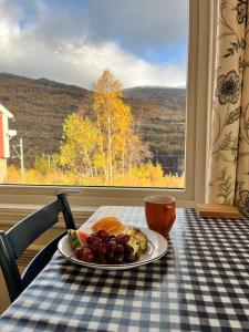 a plate of fruit on a table in front of a window at Vatnahalsen Høyfjellshotell in Myrdal