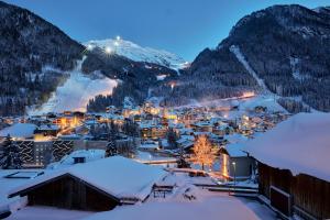eine Stadt voller Schnee in der Nacht mit Bergen in der Unterkunft Chalet Madlein in Ischgl