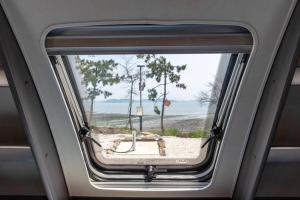 a window in a train with a view of a beach at Boseong Gaeksan Caravan Pension in Boseong