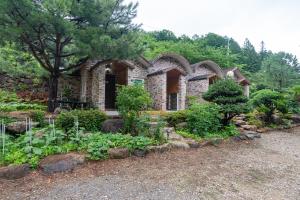 a brick house with a garden in front of it at Gwangyang Sukhee's Hwangto Pension in Gwangyang