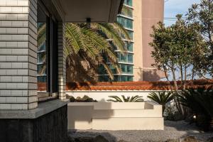 a window on a building with a palm tree at Stay Hyeopjae Soop in Jeju +58 photos