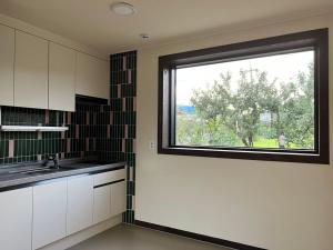 a kitchen with a large window in a kitchen at Nonsan Oyeo Poolvilla in Nonsan