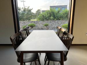 a white table and chairs in a room with a window at Nonsan Oyeo Poolvilla in Nonsan
