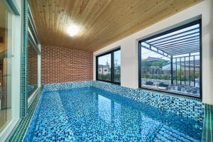 a swimming pool in a house with windows at Nonsan Oyeo Poolvilla in Nonsan