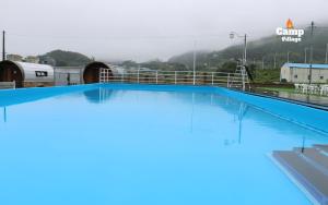 a large swimming pool with blue water on top at Camp Village Geoje in Geoje