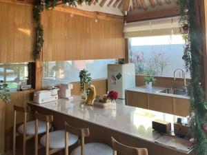a kitchen with a counter with chairs and a refrigerator at Gyeongju Onsaemi Hanok in Gyeongju