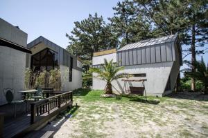 a house with a table and a tree in the yard at Jeju La Reserve in Jeju +12 photos