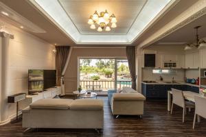 a living room with two couches and a table and a kitchen at Jeju Dumo 542 in Jeju