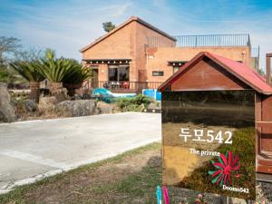 a sign in the grass in front of a building at Jeju Dumo 542 in Jeju