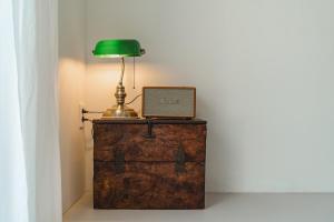 a green lamp sitting on top of a wooden chest at Jeju Mureungri The house in Murŭng-ni
