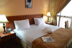 una habitación de hotel con una cama con un libro encima en Top Stars Hotel, en Abu Dabi