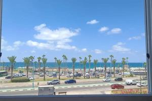 a view of a parking lot with palm trees and the ocean at Sea view flat Deganya 60-8 in Qiryat H̱ayyim
