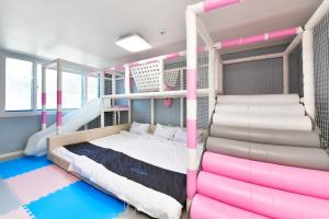 a bedroom with pink and white bunk beds at Airini Pension in Damyang