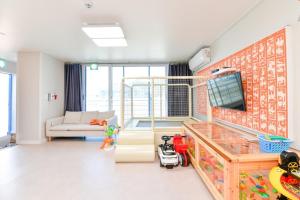 a living room with a couch and a tv at Airini Pension in Damyang +37 photos