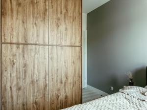 a bedroom with a large wooden cabinet next to a bed at Apartament Lipowa Centrum in Białystok +1 photo