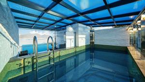an indoor swimming pool with a view of the ocean at Sacheon Azule Poolvilla in Sacheon