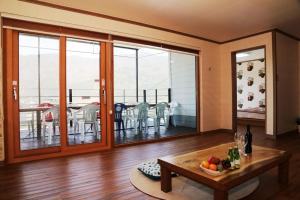 a living room with a table and a balcony at Sancheong Jirisan Noul Pension in Sancheong