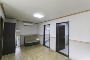 an empty room with a bed and a mirror at Daecheon Resortel in Boryeong