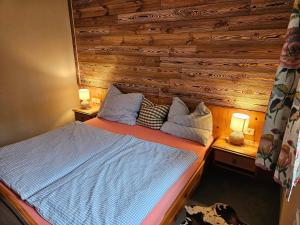 a bedroom with a bed with a wooden wall at Landhaus Eibelesee in Oberstaufen
