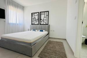 Ένα ή περισσότερα κρεβάτια σε δωμάτιο στο דירה מעוצבת בקריית אונו