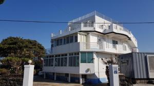 a white building with balconies on top of it at Jeju Viento Gimnyeong Pension in Jeju