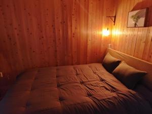 a bedroom with a bed in a wooden wall at Jeju Viento Gimnyeong Pension in Jeju