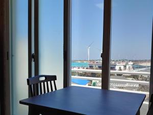 a table with a chair and a view of the ocean at Jeju Viento Gimnyeong Pension in Jeju
